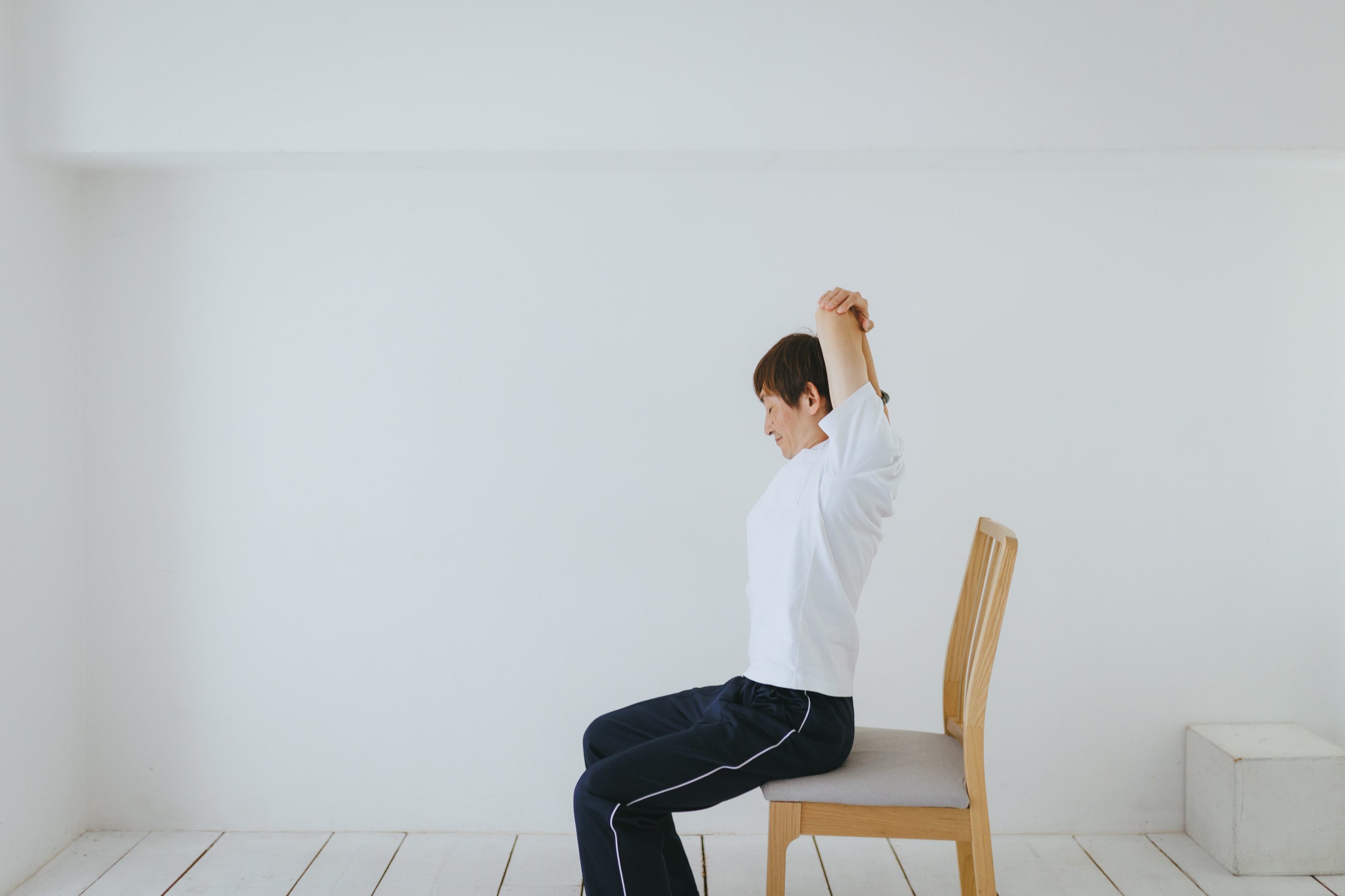椅子に座って動きを確認している田中直樹